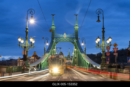 Trams crossing Liberty Bridge illuminated at night with the Gellert Hotel in the background, Budapest, Hungary-stock-foto