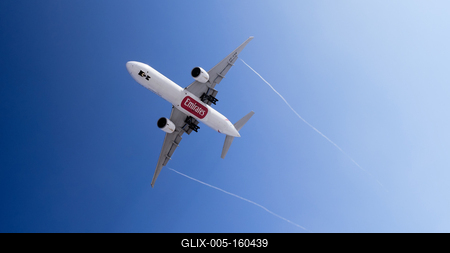 Leszálló Emirates repülő vortex csíkkal a kék égbolton-stock-foto