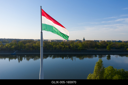 Hungary Budapest. Wind waving a  Hungarian flag. There is the Margit island on the background. Clear sky still river.-stock-foto