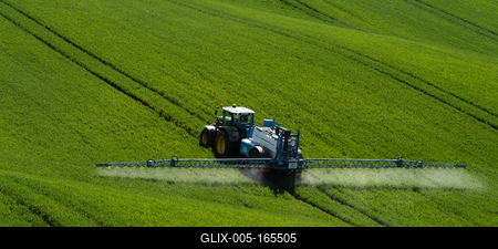 A farmer spraying on the spring wheat field with a John Deere tractor and a mamut topline sprayer.-stock-foto