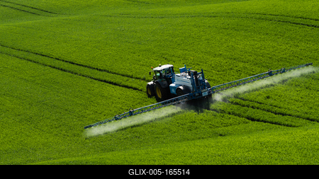 A farmer spraying on the spring wheat field with a John Deere tractor and a mamut topline sprayer.-stock-foto