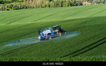 A farmer spraying on the spring wheat field with a John Deere tractor and a mamut topline sprayer.-stock-foto