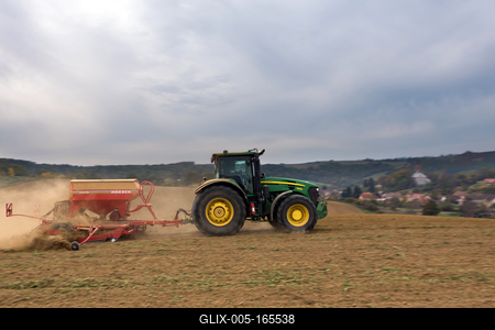 A farmer sowing with a John Deere tractor and a Horsch Pronto 4dc seeding machine. It's a panning shot, that cause the blurry background.-stock-foto