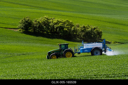 A farmer spraying on the spring wheat field with a John Deere tractor and a mamut topline sprayer.-stock-foto