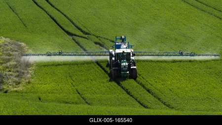 A farmer spraying on the spring wheat field with a John Deere tractor and a mamut topline sprayer.-stock-foto