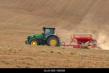 A farmer sowing with a John Deere tractor and a Horsch Pronto 4dc seeding machine. It's a panning shot, that cause the blurry background.-stock-foto