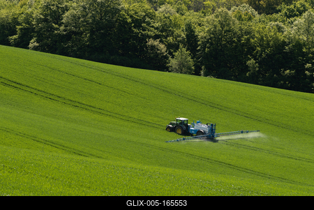 A farmer spraying on the spring wheat field with a John Deere tractor and a mamut topline sprayer.-stock-foto