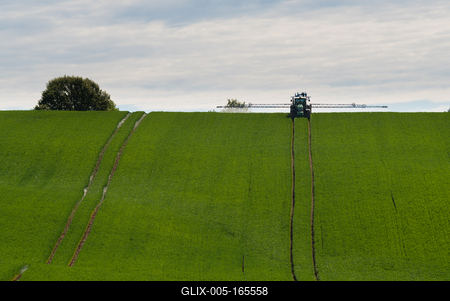 A farmer spraying on the spring wheat field with a John Deere tractor and a mamut topline sprayer.-stock-foto