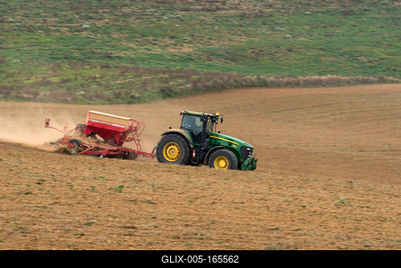 A farmer sowing with a John Deere tractor and a Horsch Pronto 4dc seeding machine. It's a panning shot, that cause the blurry background.-stock-foto