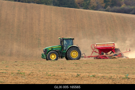 A farmer sowing with a John Deere tractor and a Horsch Pronto 4dc seeding machine. It's a panning shot, that cause the blurry background.-stock-foto