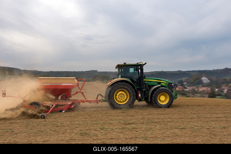 A farmer sowing with a John Deere tractor and a Horsch Pronto 4dc seeding machine. It's a panning shot, that cause the blurry background.-stock-foto