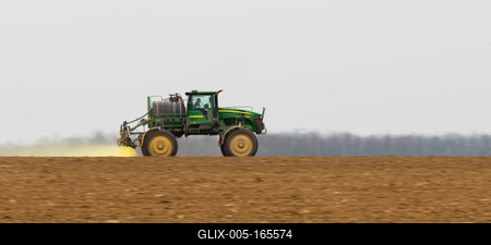 A farmer spraying with a John Deere sprayer. It's a panning shot, that's cause the blurry back and foreground.-stock-foto