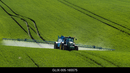 A farmer spraying on the spring wheat field with a John Deere tractor and a mamut topline sprayer.-stock-foto