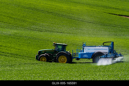 A farmer spraying on the spring wheat field with a John Deere tractor and a mamut topline sprayer.-stock-foto