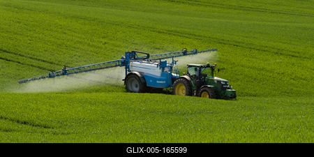 A farmer spraying on the spring wheat field with a John Deere tractor and a mamut topline sprayer.-stock-foto