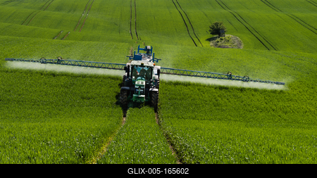 A farmer spraying on the spring wheat field with a John Deere tractor and a mamut topline sprayer.-stock-foto