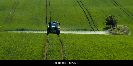 A farmer spraying on the spring wheat field with a John Deere tractor and a mamut topline sprayer.-stock-foto