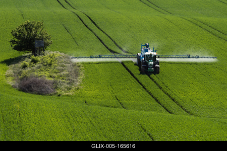 A farmer spraying on the spring wheat field with a John Deere tractor and a mamut topline sprayer.-stock-foto