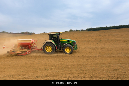 A farmer sowing with a John Deere tractor and a Horsch Pronto 4dc seeding machine. It's a panning shot, that cause the blurry background.-stock-foto