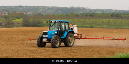 A farmer spraying with a Landini Evolution 9880 tractor. It's a panning shot, that's cause the blurry in the back and foreground.-stock-foto