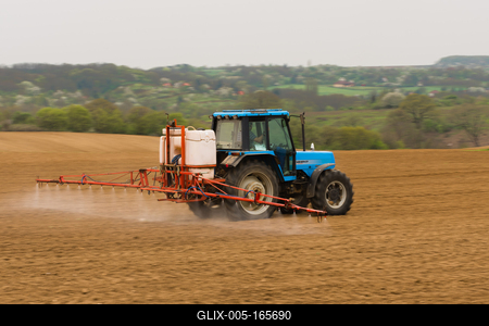 A farmer spraying with a Landini Evolution 9880 tractor. It's a panning shot, that's cause the blurry in the back and foreground.-stock-foto