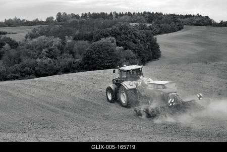 A farmer sowing with a John Deere tractor and a Horsch Pronto 4dc seeding machine. Black and white.-stock-foto