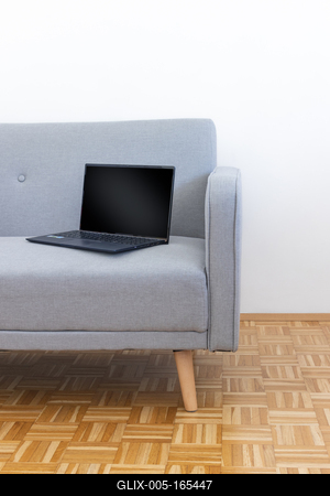 Laptop on the grey couch-stock-foto
