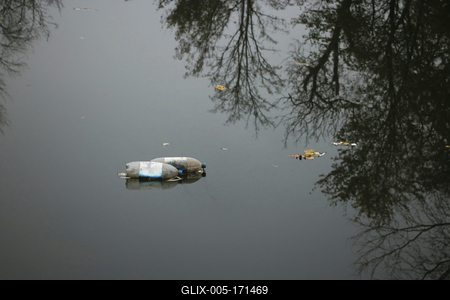 Dirty, empty bottles float in the river in autumn.-stock-foto
