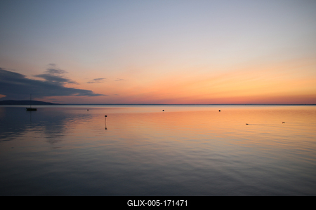 Sunrise at lake with sailboat-stock-foto