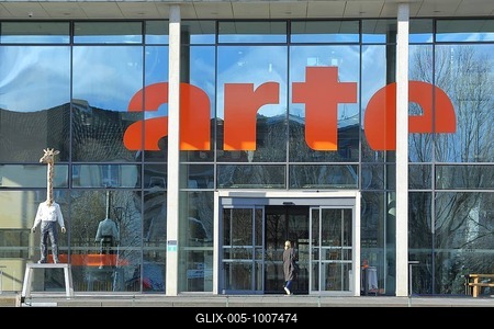 Entrance to the modern building of the broadcasting station Arte of ARD and ZDF with sculpture Giraffe Man Sculpture Giraffe Man by Stephan Balkenhol, giraffe figure, giraffe man, animal figure, man figure, giraffe neck, mythical creature, pedestrian, inscription, television station, broadcasting, Strasbourg, Bas-Rhin, Alsace, France-stock-foto