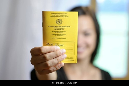 Young woman holding her vaccination card into the camera-stock-foto