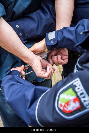 Police officer putting handcuffs on an offender, NRW Police, North Rhine-Westphalia, Germany-stock-foto