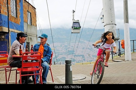 Men sitting in a street café, girl riding a bicycle, Metrocable cable car at back, slums, Comuna 13, Medellin, Colombia, South America, Latin America, America-stock-foto