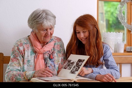 Granddaughter and grandmother looking at a photo album, Bavaria, Germany-stock-foto
