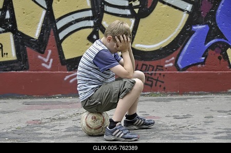 Disappointed and lonely boy with his football in front of a graffiti wall, kickabout area in Cologne, North Rhine-Westphalia, Germany, Europe-stock-foto