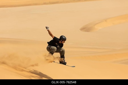 Sand boarding in the dunes of the Namib Desert, near Swakopmund, Namibia-stock-foto
