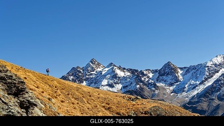 Mountaineer on ridge with snow-covered South Tyrolean mountains in autumnal mountain landscape, Martell Valley, Naturno, South Tyrol, Italy-stock-foto
