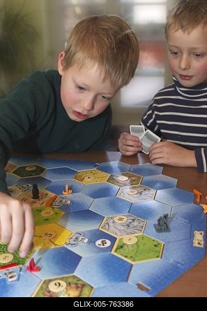 Two seven and nine year old boys playing The Settlers of Catan - The Seafarer's Expansion Set-stock-foto