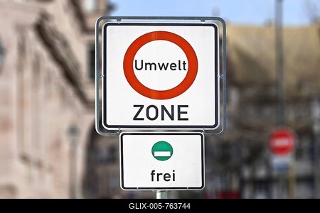 Road traffic sign marking a low emission zone in city centers in Germany translating as Environmental Zone and sign showing cars with green environmental badge a free to enter-stock-foto