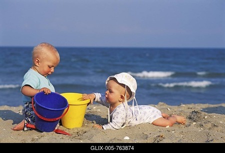Two babies playing at the beach MR-stock-foto