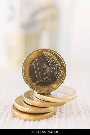 Upright one Euro coin on top of stacked coins-stock-foto