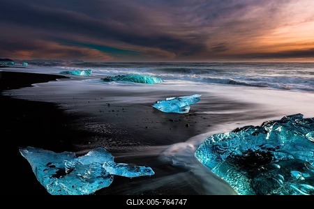 Chunks of ice on black lava sand beach at sunrise, lake Jökulsárlón, Vik, Iceland-stock-foto