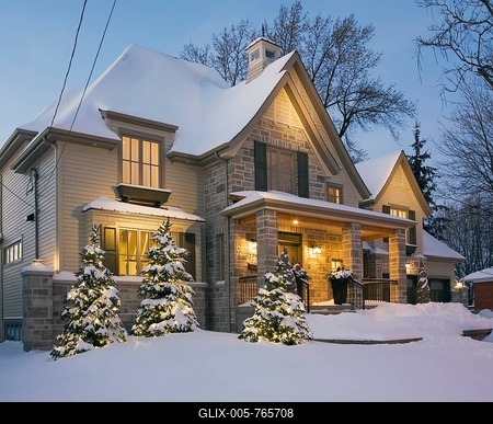 Luxurious residential cottage style home with illuminated evergreen trees at dusk in winter, Quebec, Canada-stock-foto