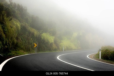 Curvy street in the fog with mossy mountain slope, Ponta Delgada, Flores Island, Azores, Portugal-stock-foto