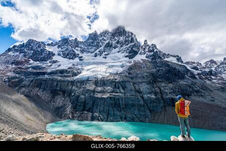Hiker standing at the lagoon, glacial lake at Cerro Castillo mountain, Cerro Castillo National Park, Aysen, Patagonia, Chile-stock-foto