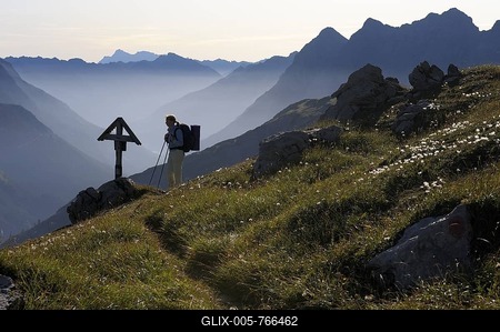Mountaineer in front of memorial cross in the morning light, Hinterhornbach, Lechtal, Ausserfern, Tyrol, Austria, Europe-stock-foto
