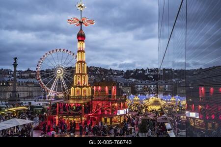 Christmas market Stuttgart, Christmas pyramid from the Erzgebirge at the Schlossplatz in the evening, in the background the Ferris wheel and the Neues Schloss, Stuttgart, Baden-Württemberg, Germany-stock-foto