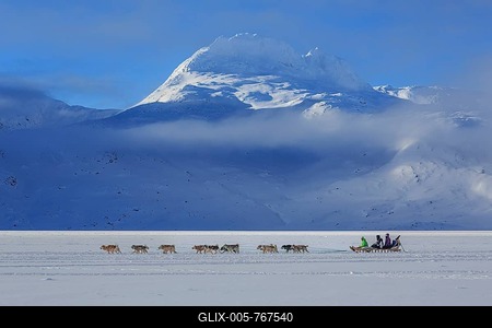 Tourists on dog sleds in front of snowy mountains, winter, sunny, Ammassalik District, East Greenland, Greenland-stock-foto