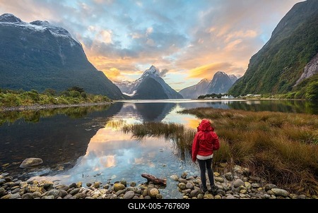 Tourist looking at the landscape, Miter Peak reflected in the water, sunset, Milford Sound, Fiordland National Park, Te Anau, Southland Region, Southland, New Zealand, Oceania-stock-foto