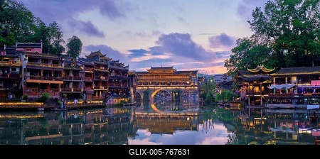 Chinese tourist attraction destination, panorama of Feng Huang Ancient Town (Phoenix Ancient Town) on Tuo Jiang River illuminated at night. Hunan Province, China-stock-foto